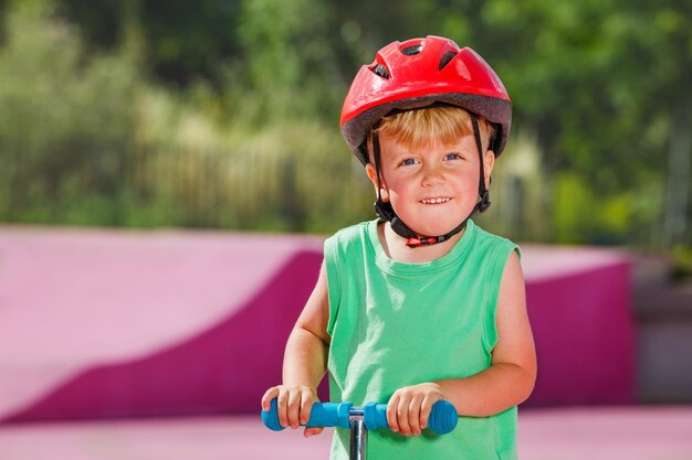 Retrato de un niño lindo de pie en la carretera.