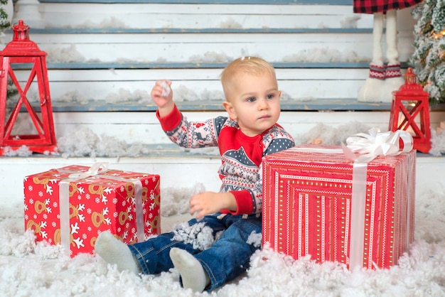 Retrato de un niño lindo con un regalo en sus manos cerca del árbol de navidad para navidad