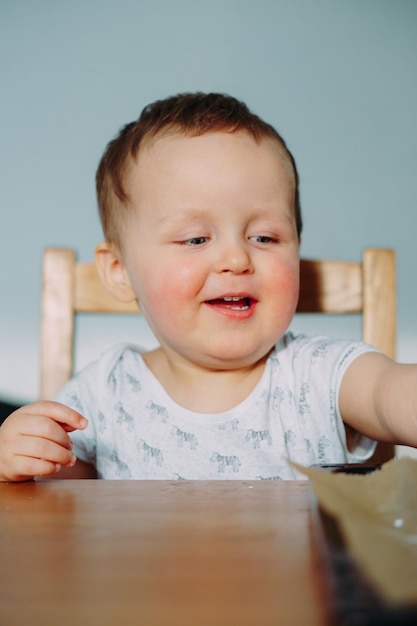 Foto retrato de un niño lindo sentado en la mesa