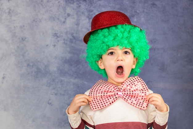 Foto retrato de un niño lindo con sombrero de pie contra la pared