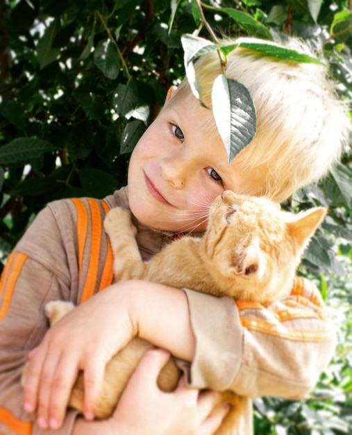 Retrato de un niño lindo sosteniendo un gatito