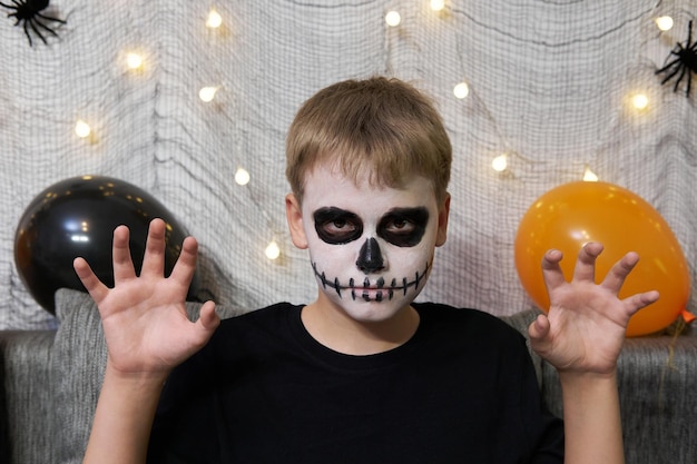 Retrato de un niño con maquillaje en la cara en forma de esqueleto para Halloween