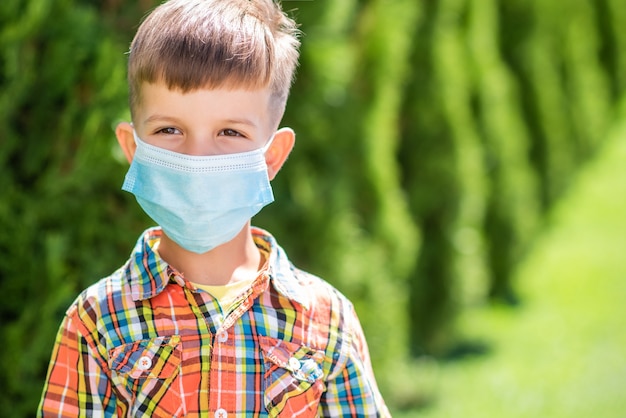 Retrato de un niño con una máscara protectora en la calle durante la pandemia de coronavirus y Covid - 19