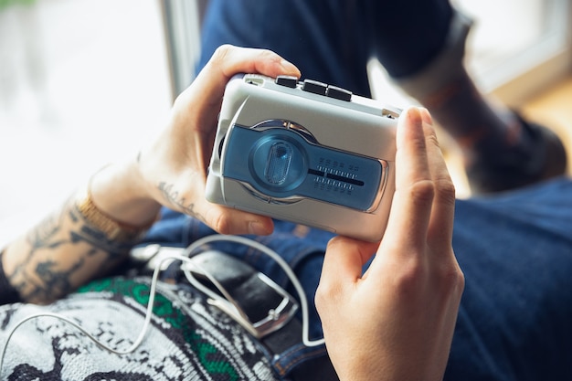 Retrato de niño milenario usando juguetes retro, conociendo cosas del pasado y divirtiéndose. La generación de dispositivos digitales explora el entretenimiento del pasado. Los recuerdos de la primera infancia, de nuevo en tendencia.