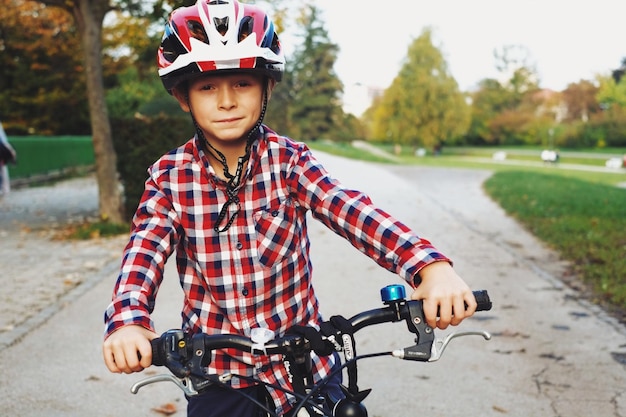 Retrato de un niño montando en bicicleta en la carretera