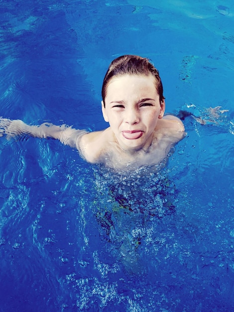 Foto retrato de un niño nadando en una piscina