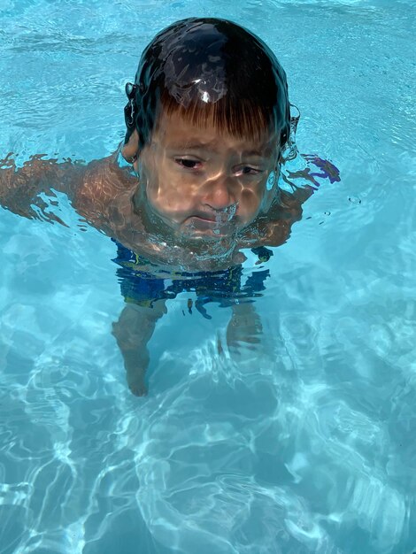 Foto retrato de un niño nadando en una piscina