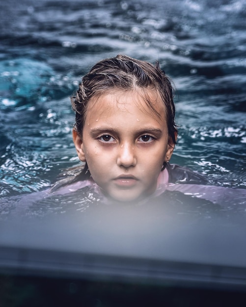 Foto retrato de un niño nadando en una piscina