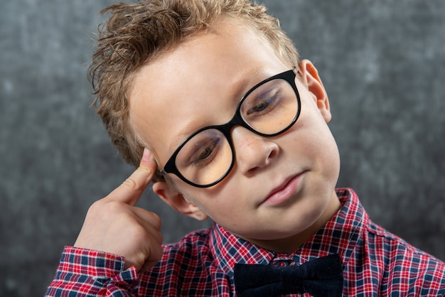 Retrato de un niño pensativo con gafas