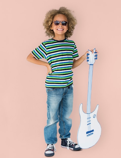 Retrato de un niño pequeño afrodescendiente con una guitarra aislada