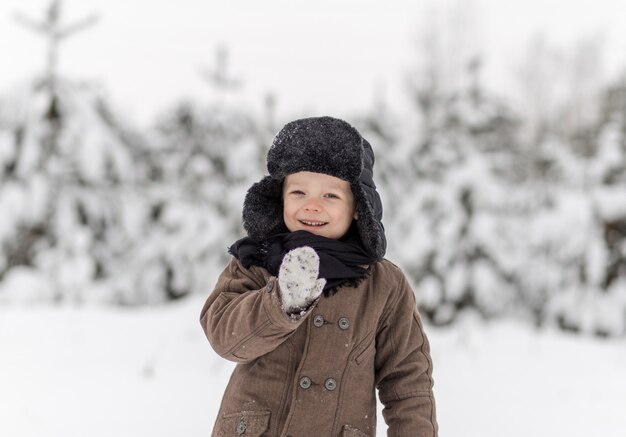 Retrato de un niño pequeño en un bosque de invierno