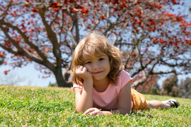 Retrato de niño pequeño Concepto de niños tendidos en la hierba Los niños de otoño caen las hojas