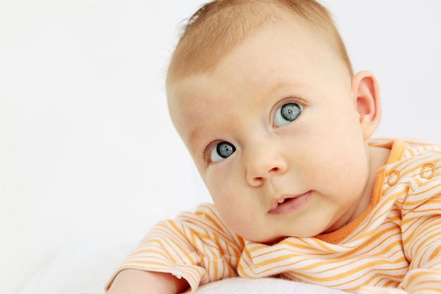 Retrato de niño pequeño curioso sobre el blanco