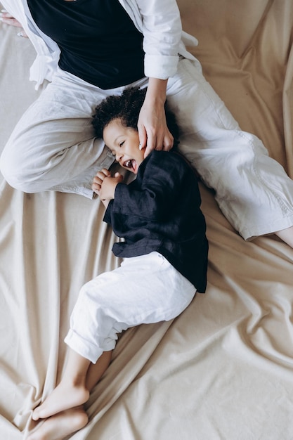 Retrato de un niño pequeño con estilo que se ríe sinceramente con una hermosa sonrisa