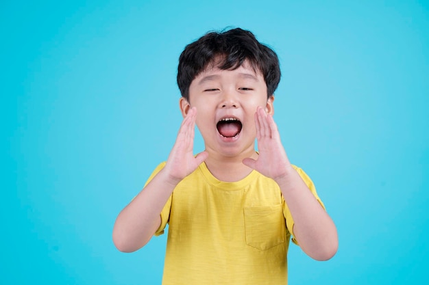 Retrato de niño pequeño guapo asiático aislado sobre fondo azul.