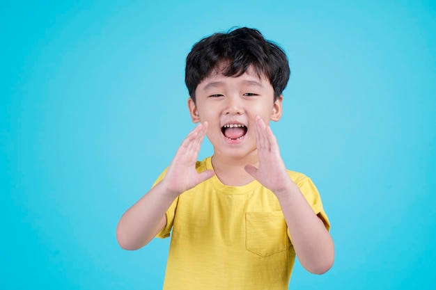 Retrato de niño pequeño guapo asiático aislado sobre fondo azul.