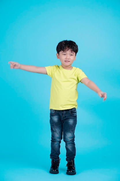 Retrato de niño pequeño guapo asiático aislado sobre fondo azul.