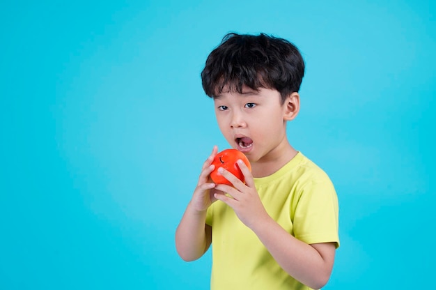 Retrato de niño pequeño guapo asiático aislado sobre fondo azul.