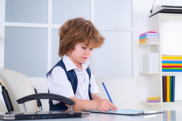 Retrato de niño pequeño hombre sentado en su escritorio en la oficina niño empresario en su oficina des