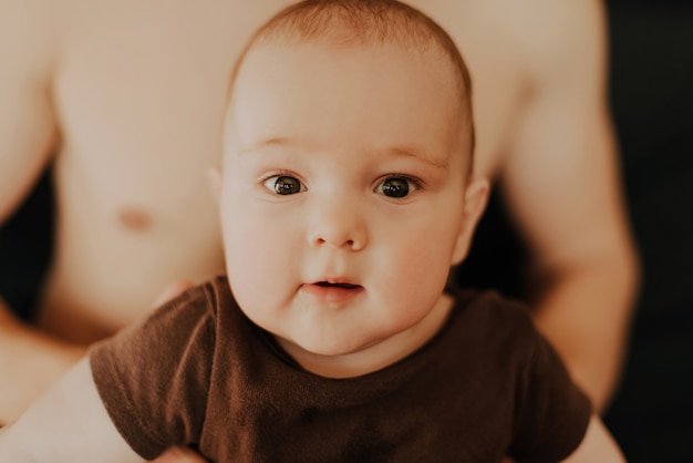 Retrato de niño pequeño niño caucásico hijo en manos del padre