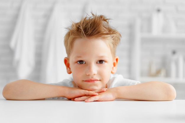 Retrato de niño pequeño de pie en un baño de luz