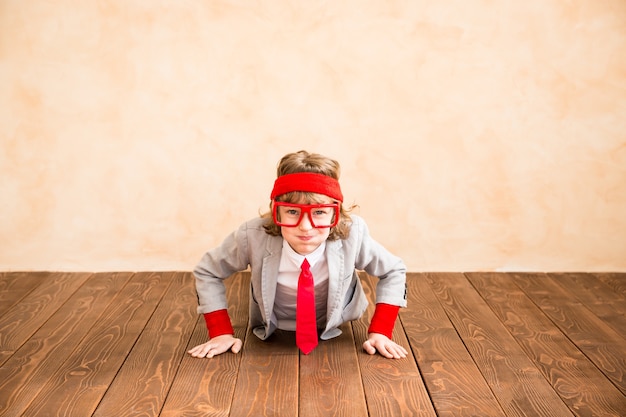 Retrato de niño pequeño pretende ser empresario. Niño jugando en casa. Éxito, idea y concepto creativo. Copie el espacio para su texto