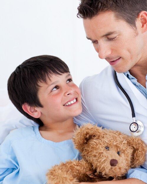 Retrato de un niño pequeño sonriente y su médico