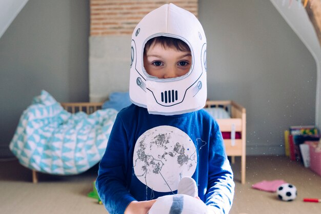 Foto retrato de un niño pequeño con un traje de casco de astronauta