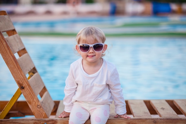 Retrato de un niño pequeño en una tumbona con sun ochkami. Felicidad, vacaciones, recurso, viaje, sonrisa, verano, calor