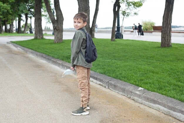 Foto retrato de un niño de pie en un sendero en un parque