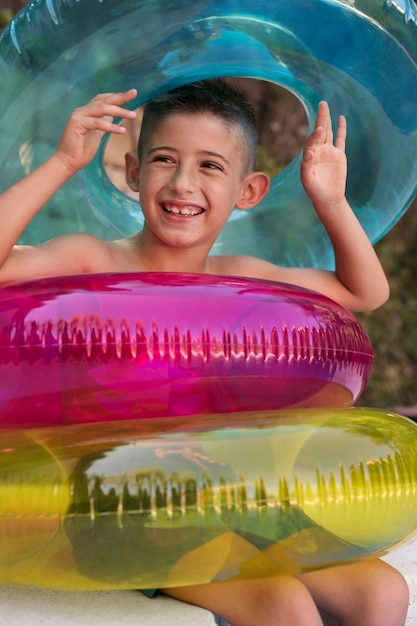 Retrato de niño en la piscina con flotador