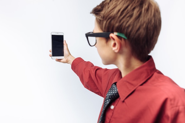 El retrato de un niño positivo y emocional se toma una selfie en su teléfono inteligente