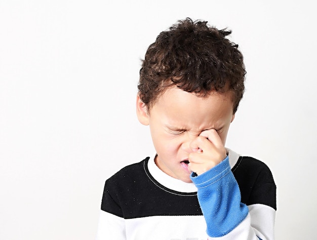 Retrato de un niño que mira hacia otro lado contra un fondo blanco