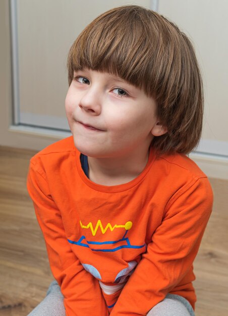 Foto retrato de un niño sentado en casa