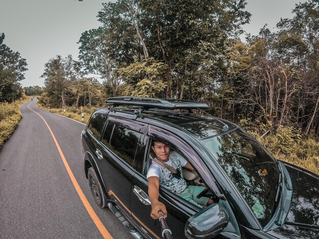 Foto retrato de un niño sentado en un estacionamiento