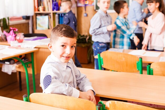 Foto retrato de un niño sentado en una mesa