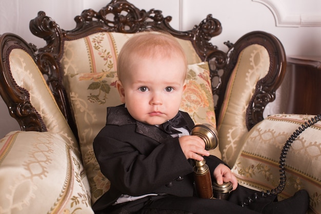 Retrato de niño sentado en un sillón