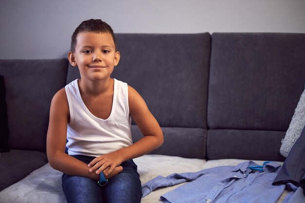 Foto retrato de un niño sentado en el sofá en casa