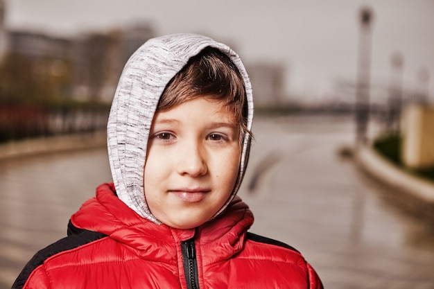 Retrato de niño de siete años en ropa de abrigo al aire libre.