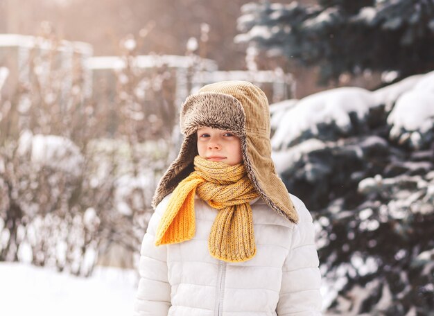 Retrato de un niño con un sombrero de invierno en invierno en un día soleado