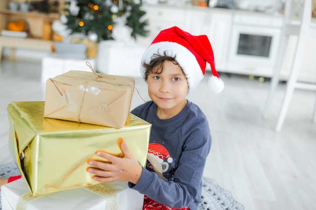 Retrato de un niño con sombrero y regalos de Navidad