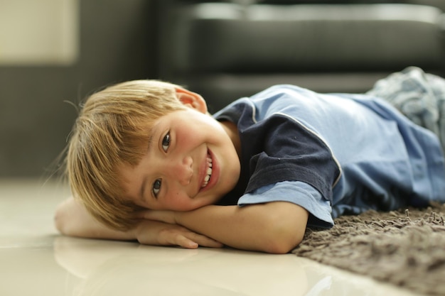 Retrato de un niño sonriente acostado en casa