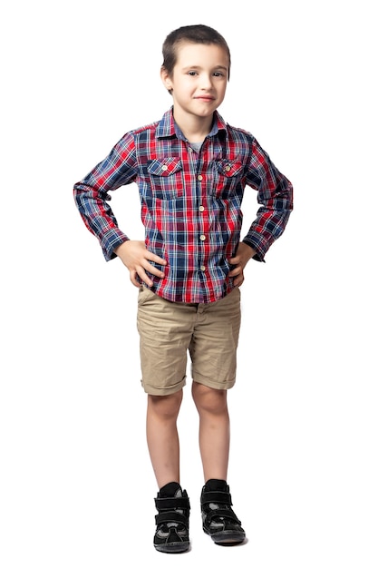 Foto retrato de un niño sonriente en camisa a cuadros está tomados de la mano a los lados, mirando con picardía y divirtiéndose en un blanco