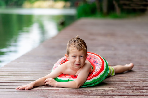 Retrato de un niño sonriente cerca del lago