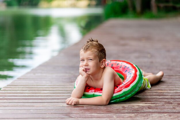 Retrato de un niño sonriente cerca del lago