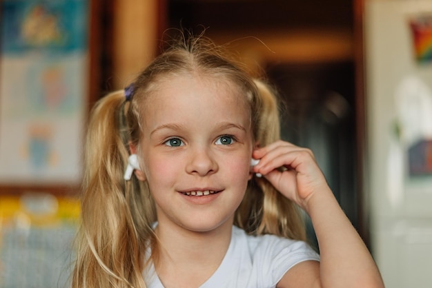 retrato de un niño sonriente escuchando música con auriculares blancos bailando jugando en casa