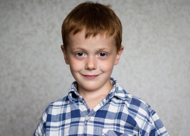 Foto retrato de un niño sonriente de jengibre con pecas