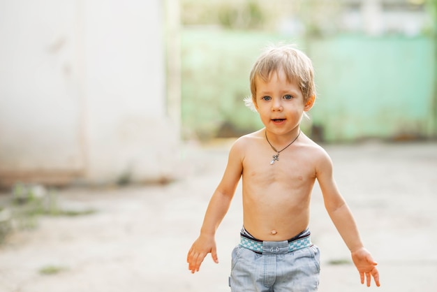 Retrato de niño sonriente lindo en el verde del jardín de verano