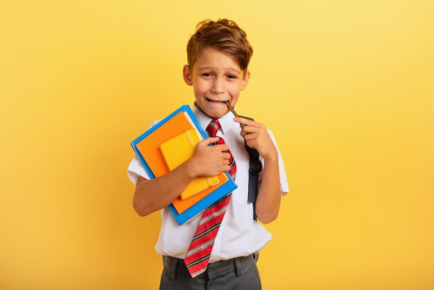 Foto retrato de un niño sonriente de pie contra un fondo amarillo