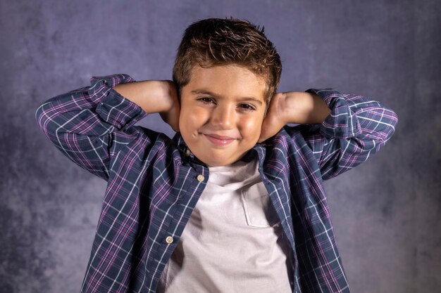 Foto retrato de un niño sonriente de pie contra la pared